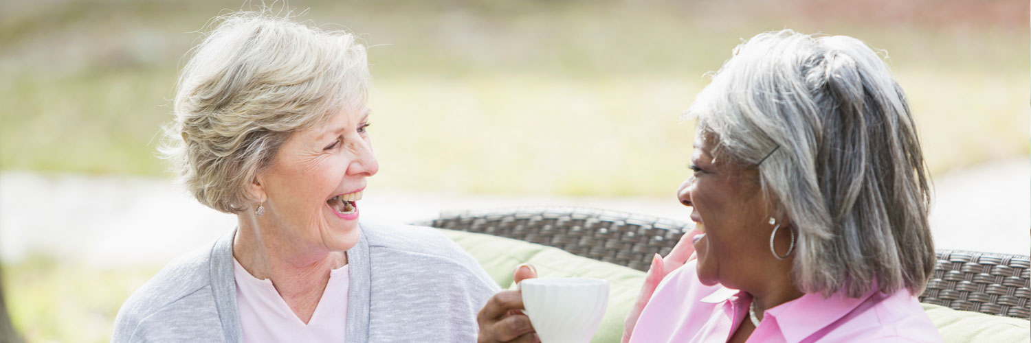 Two elderly women talking and having coffee